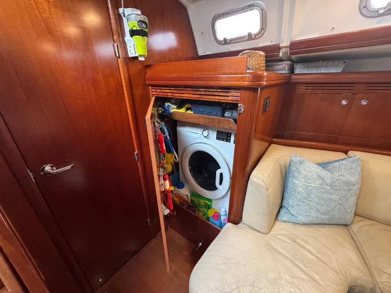 Slide: The Image of Interior of 2005 Beneteau 523 Oceanis yacht with washing machine and cozy seating area. - 15