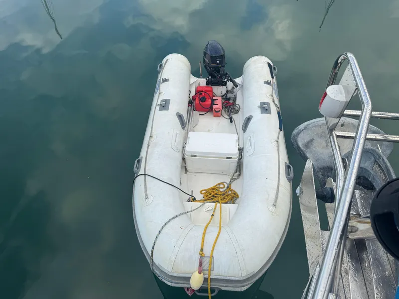 Slide: The Image of Inflatable dinghy tied to a Beneteau 523 Oceanis, 2005 model, floating on calm water. - 29