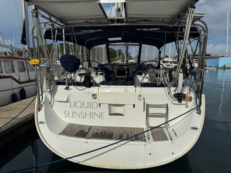 Slide: The Image of 2005 Beneteau 523 Oceanis sailboat docked, rear view with "Liquid Sunshine" name visible. - 5