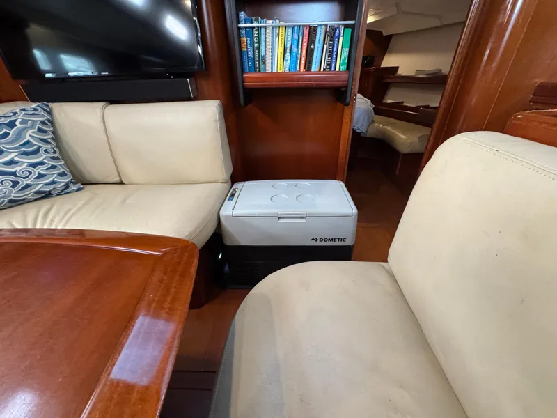 Slide: The Image of Interior of 2005 Beneteau 523 Oceanis yacht with seating, books, and a Dometic cooler. - 9