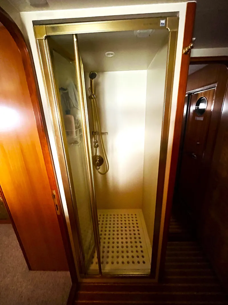 Slide: The Image of Shower cabin in 2004 Grand Harbour Motor Yacht with gold accents and wooden flooring. - 13