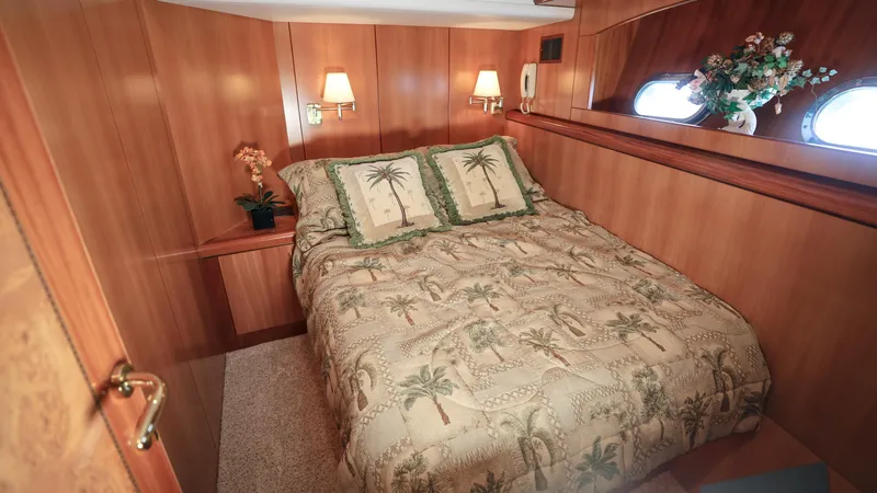 Slide: The Image of Luxurious 2004 Grand Harbour Motor Yacht bedroom with elegant wood paneling and cozy bedding. - 14