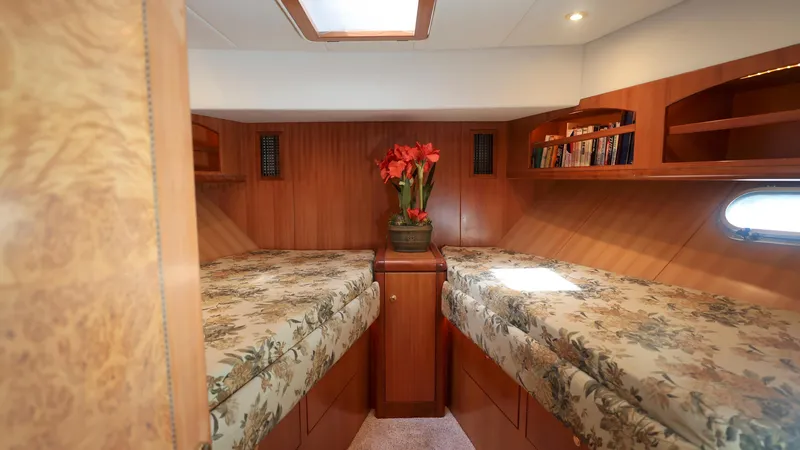 Slide: The Image of Luxurious 2004 Grand Harbour Motor Yacht cabin with twin beds and elegant wood finish. - 16