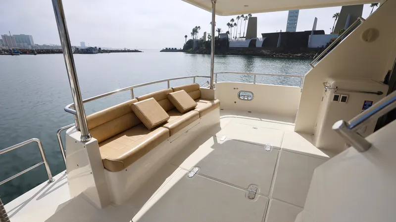 Slide: The Image of Grand Harbour 2004 motor yacht deck with seating, overlooking calm waters and distant shoreline. - 22
