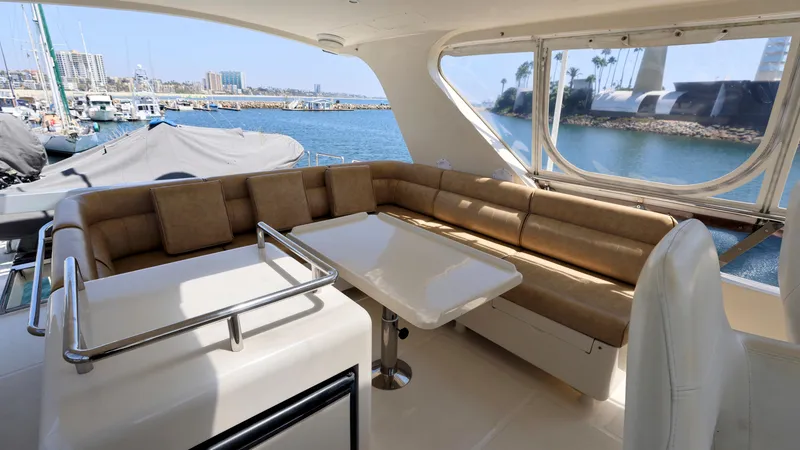 Slide: The Image of Luxurious 2004 Grand Harbour Motor Yacht interior with plush seating and scenic marina view. - 26