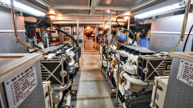 Slide: The Image of Engine room of a 2004 Grand Harbour Motor Yacht, featuring dual engines and organized layout. - 35