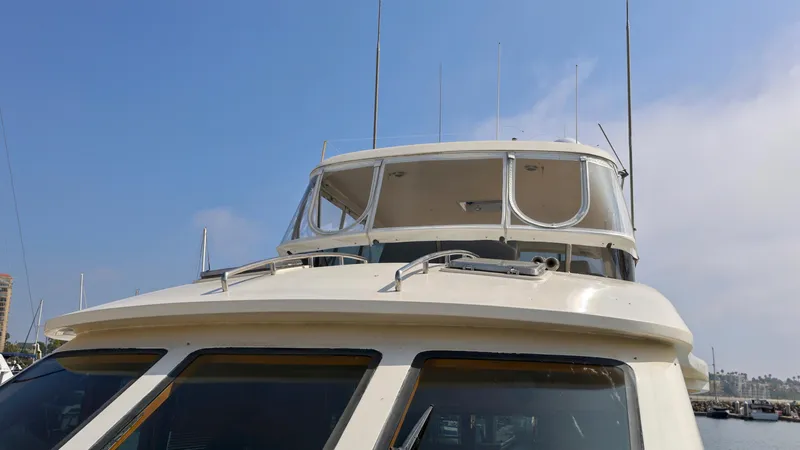 Slide: The Image of 2004 Grand Harbour Motor Yacht with antennas, docked under a clear blue sky. - 40