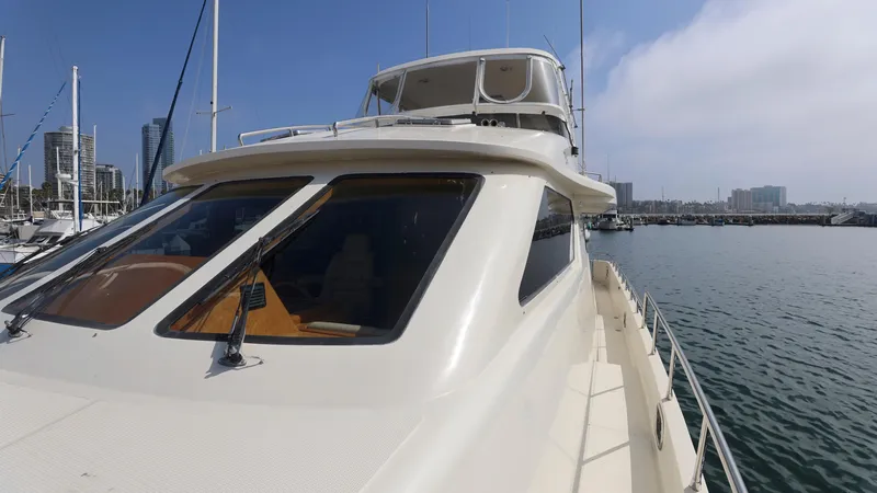 Slide: The Image of Grand Harbour 2004 motor yacht docked in marina, clear sky, city skyline in background. - 43