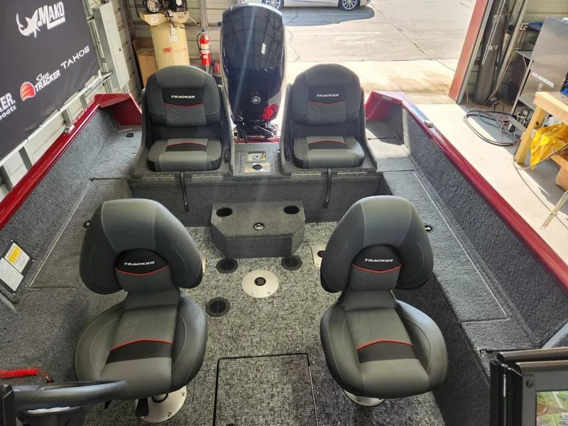 Slide: The Image of 2025 Tracker Pro Guide V-175 Combo boat interior with four seats in a garage setting. - 14