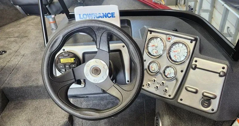 Slide: The Image of 2025 Tracker Pro Guide V-175 Combo boat dashboard with steering wheel and gauges. - 3