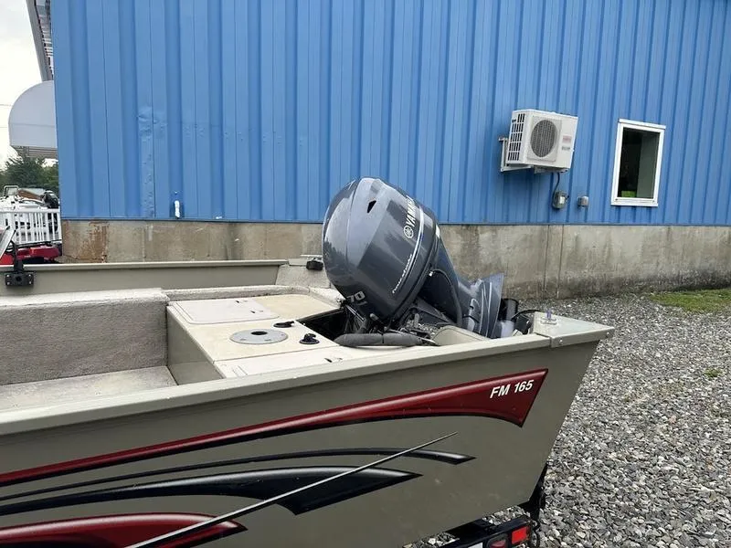 Slide: The Image of 2007 Lowe FM 165 boat with outboard motor near blue building. - 2