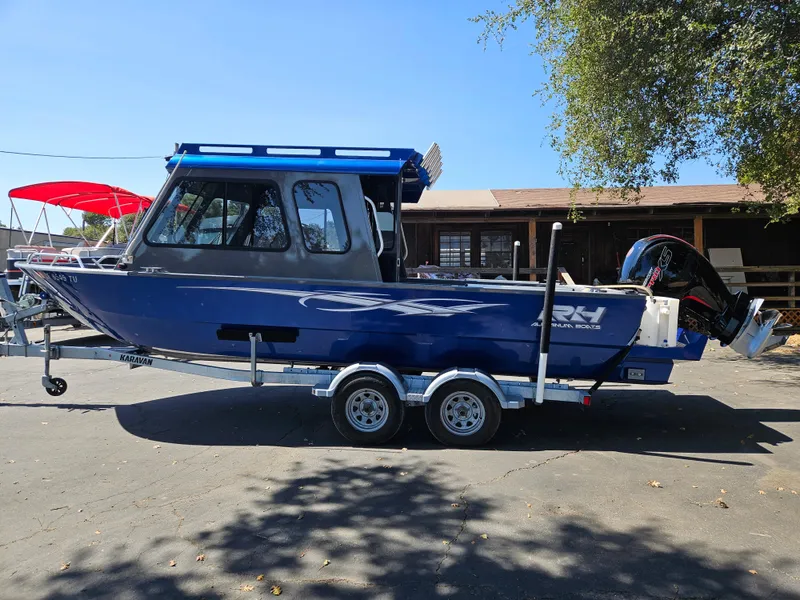 Slide: The Image of 2022 RH Boats Coastal 22 Hardtop on trailer, parked outdoors. - 1