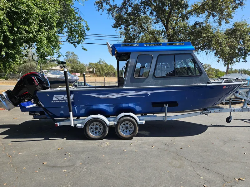 Slide: The Image of 2022 RH Boats Coastal 22 Hardtop on trailer, parked outdoors. - 2