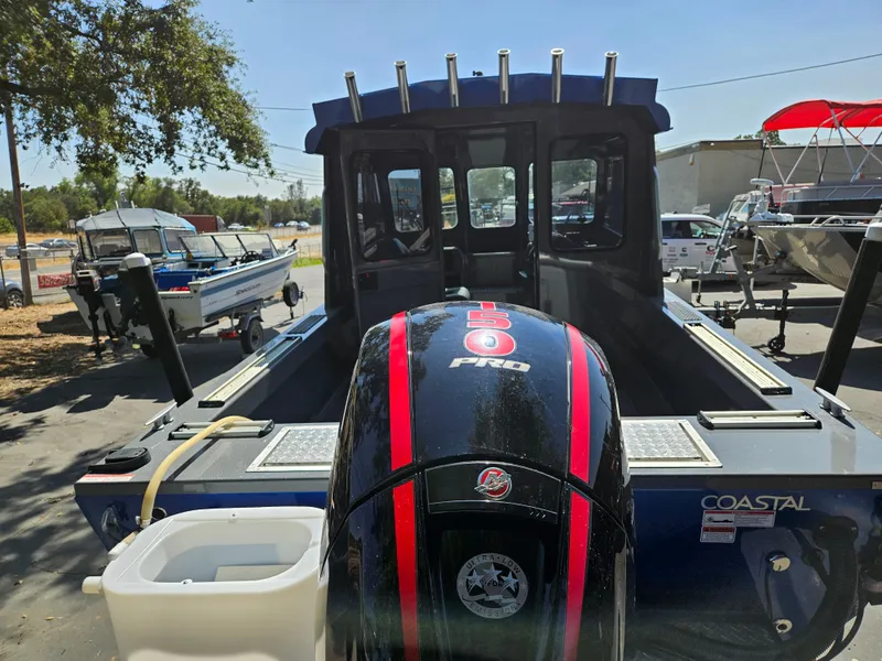 Slide: The Image of 2022 RH Boats Coastal 22 Hardtop with powerful outboard motor in a marina setting. - 4