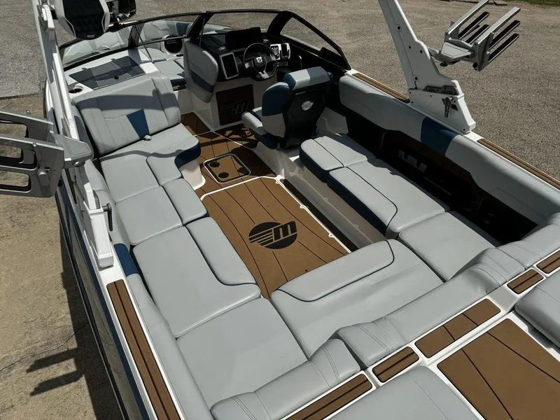 Slide: The Image of 2022 Malibu 23 LSV boat interior with sleek seating and modern dashboard design. - 10