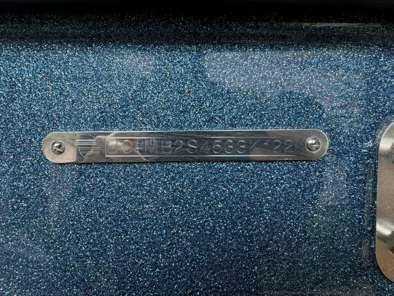 Slide: The Image of 2022 Malibu 23 LSV boat identification plate on metallic blue surface. - 14