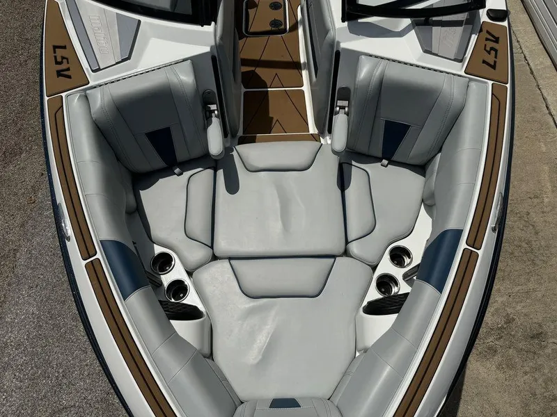 Slide: The Image of 2022 Malibu 23 LSV boat interior with gray seating and cup holders. - 2
