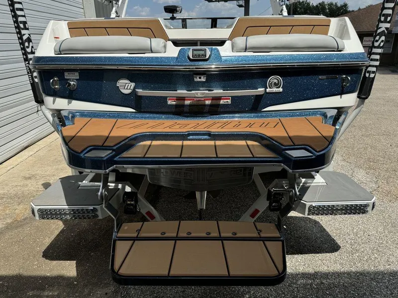 Slide: The Image of 2022 Malibu 23 LSV boat rear view with teak deck and blue accents. - 3