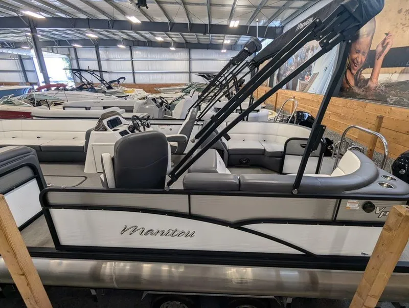 Slide: The Image of 2022 Manitou 23 Aurora LE RF VP pontoon boat in showroom. - 0