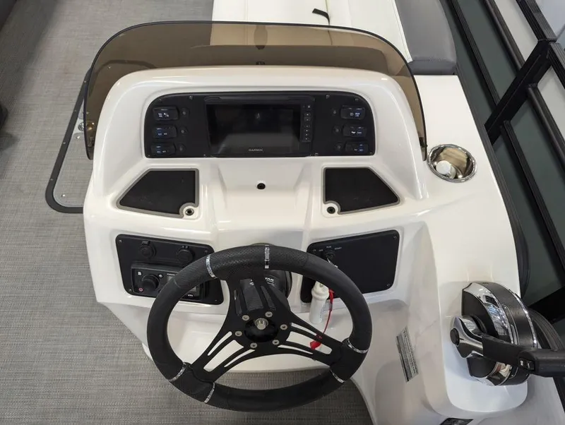 Slide: The Image of 2022 Manitou 23 Aurora LE RF VP boat dashboard with steering wheel and controls. - 10