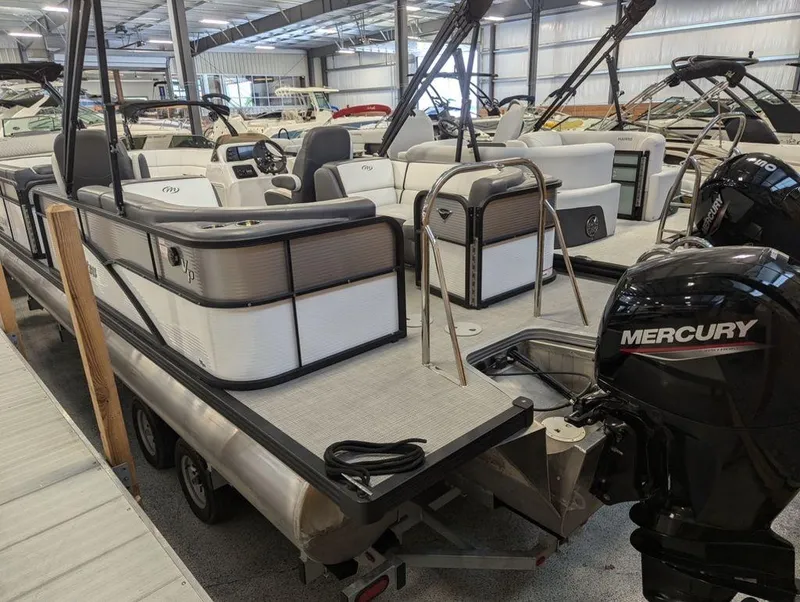 Slide: The Image of 2022 Manitou 23 Aurora LE RF VP pontoon boat with Mercury engine in showroom. - 2