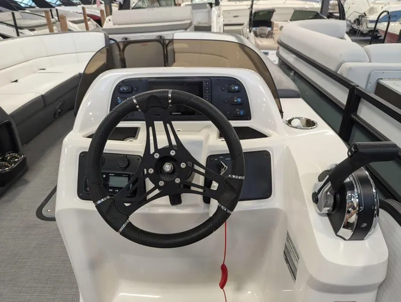 Slide: The Image of 2022 Manitou 23 Aurora LE RF VP boat dashboard with steering wheel and controls. - 9