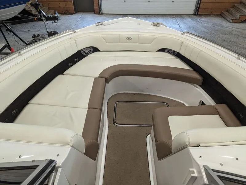 Slide: The Image of Interior of 2014 Cobalt 296 boat with white and brown seating in a garage. - 11