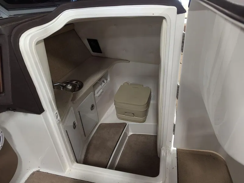 Slide: The Image of 2014 Cobalt 296 boat interior cabin with compact toilet and sink. - 12