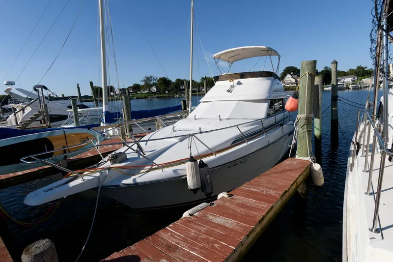 The Image of 1992 Silverton 34 Convertible yacht docked at marina, clear sky, calm water. - 0