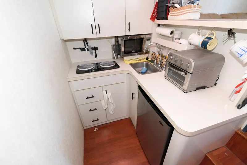 Slide: The Image of Compact kitchen in a 1992 Silverton 34 Convertible boat with stove, sink, and appliances. - 18