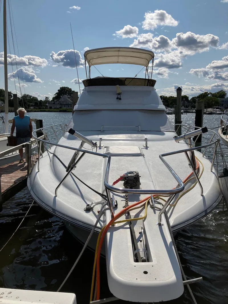 Slide: The Image of 1992 Silverton 34 Convertible yacht docked at marina under a partly cloudy sky. - 3