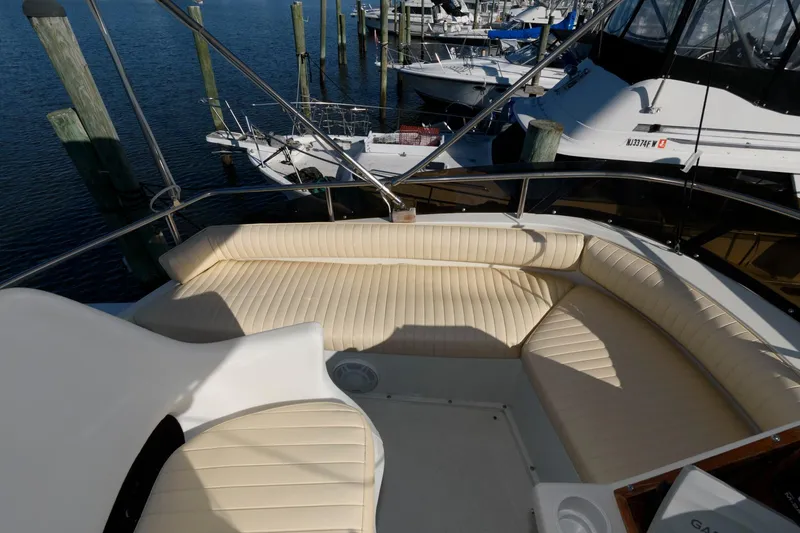 Slide: The Image of 1992 Silverton 34 Convertible yacht with beige seating, docked at a marina. - 5