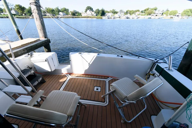 Slide: The Image of 1992 Silverton 34 Convertible boat deck with chairs, overlooking serene waterfront and dock. - 7
