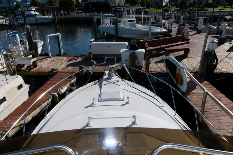 Slide: The Image of 1992 Silverton 34 Convertible docked at a marina, surrounded by other boats. - 8