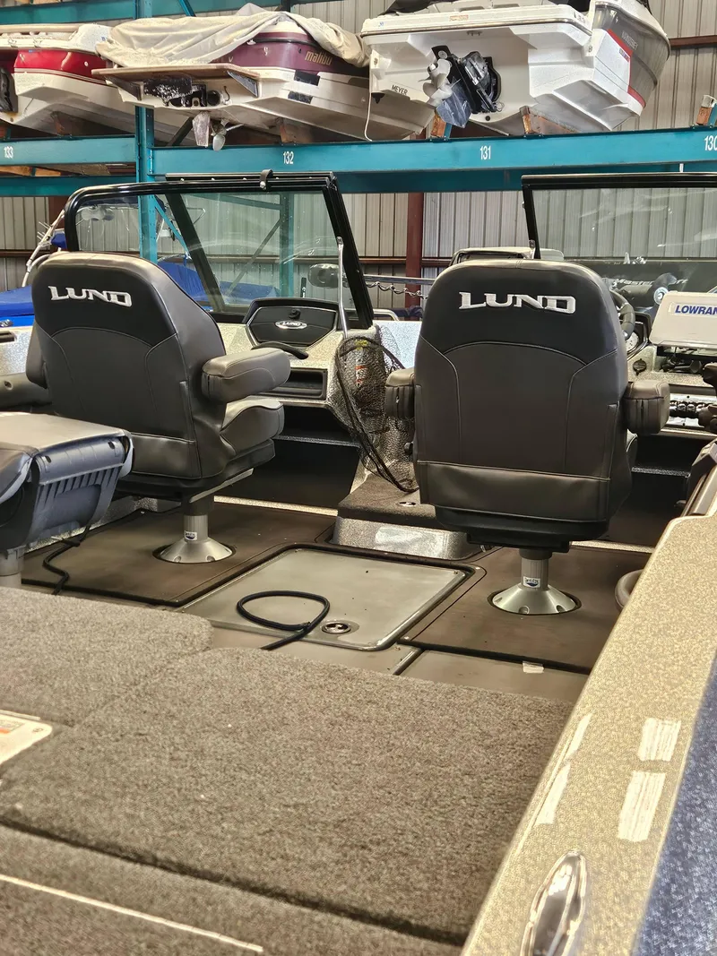 Slide: The Image of 2022 Lund TYEE boat interior with two seats in a showroom. - 6