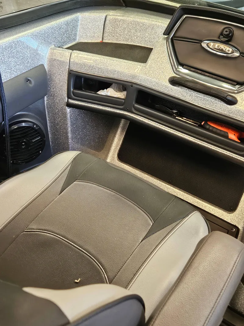 Slide: The Image of 2022 Lund TYEE boat interior with gray seating and dashboard details. - 8