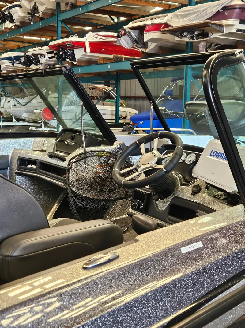 Slide: The Image of 2022 Lund TYEE boat interior with steering wheel and Lowrance equipment. - 9