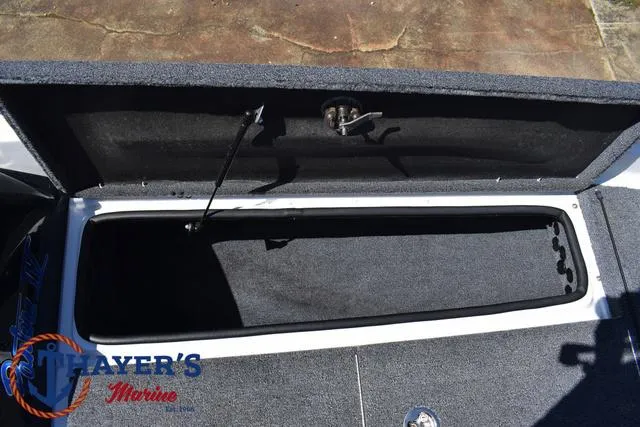 Slide: The Image of 2012 Bass Cat Pantera IV boat storage compartment, open lid, carpeted interior. - 17