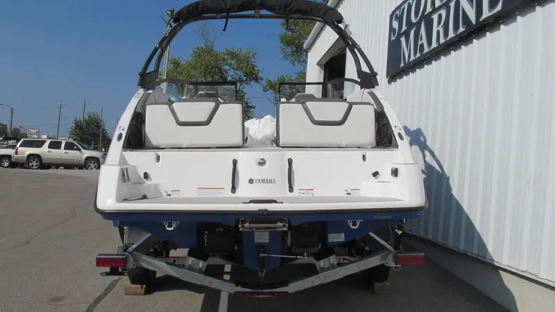 Slide: The Image of 2025 Yamaha Boats AR250 on trailer outside marine store. - 3