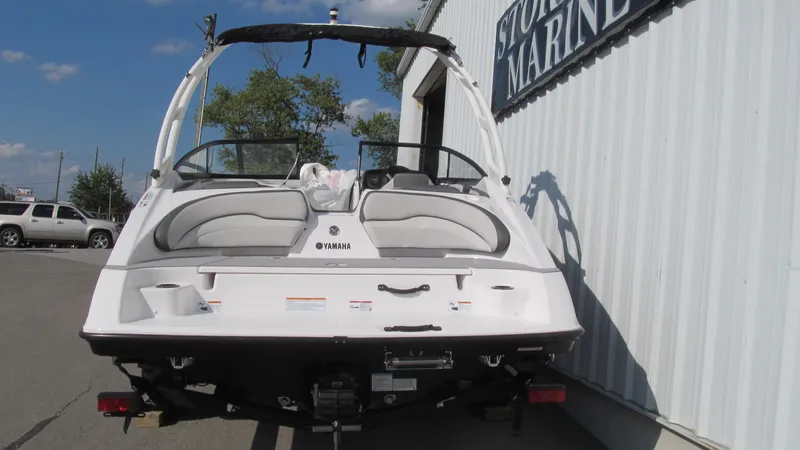 Slide: The Image of 2025 Yamaha AR190 boat, white exterior, parked near a marine store. - 3