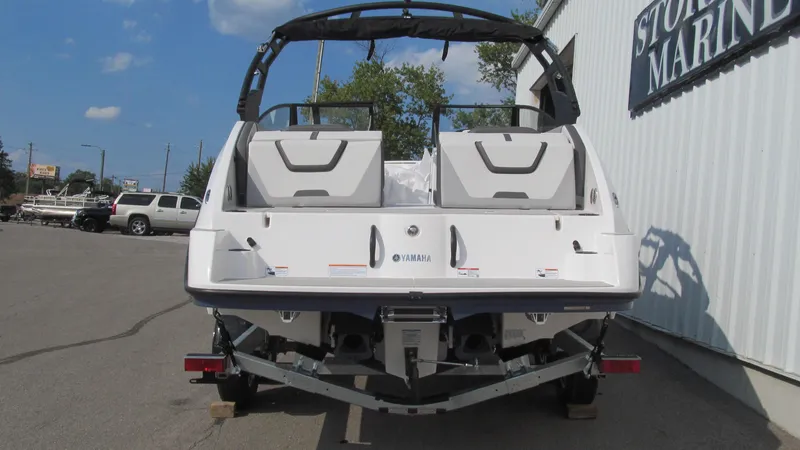 Slide: The Image of 2025 Yamaha Boats AR220, rear view at marina, on trailer. - 3