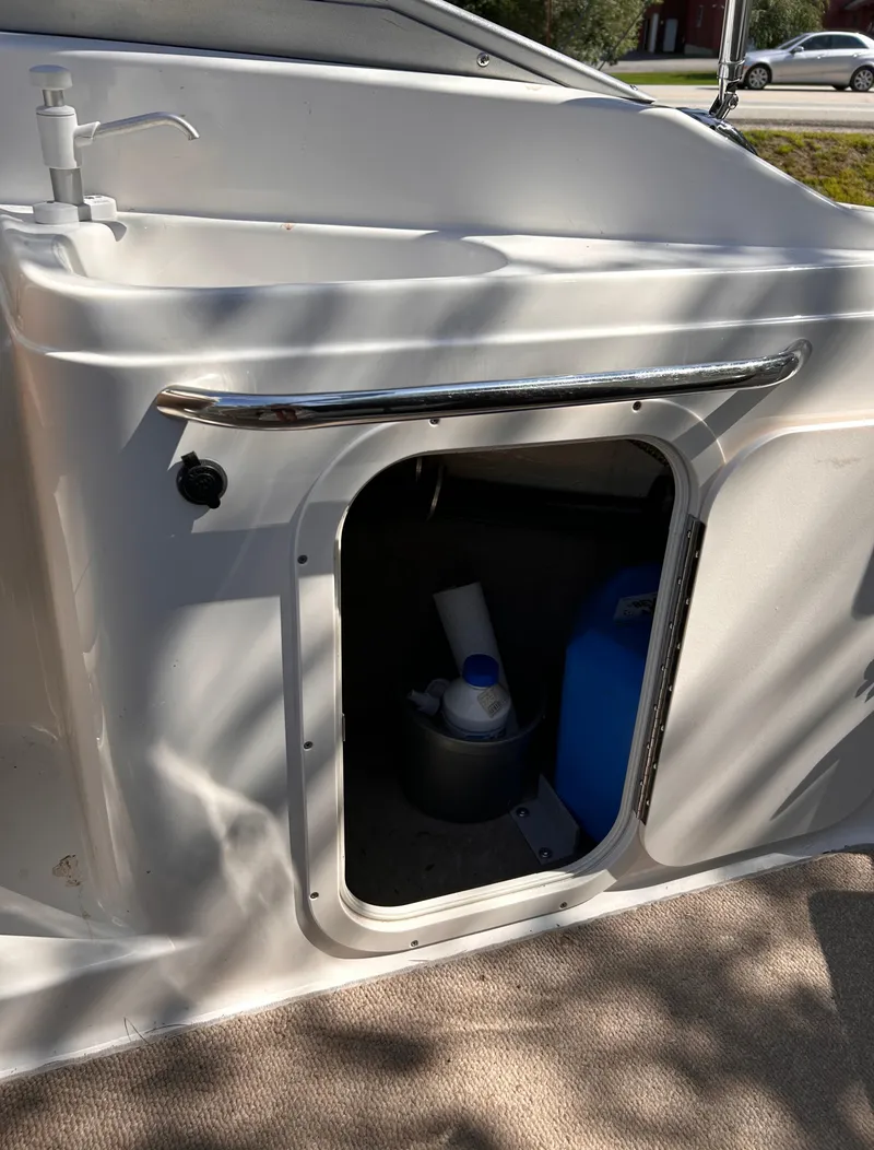 Slide: The Image of 2005 Chaparral 215 SSi boat storage compartment with cleaning supplies. - 17