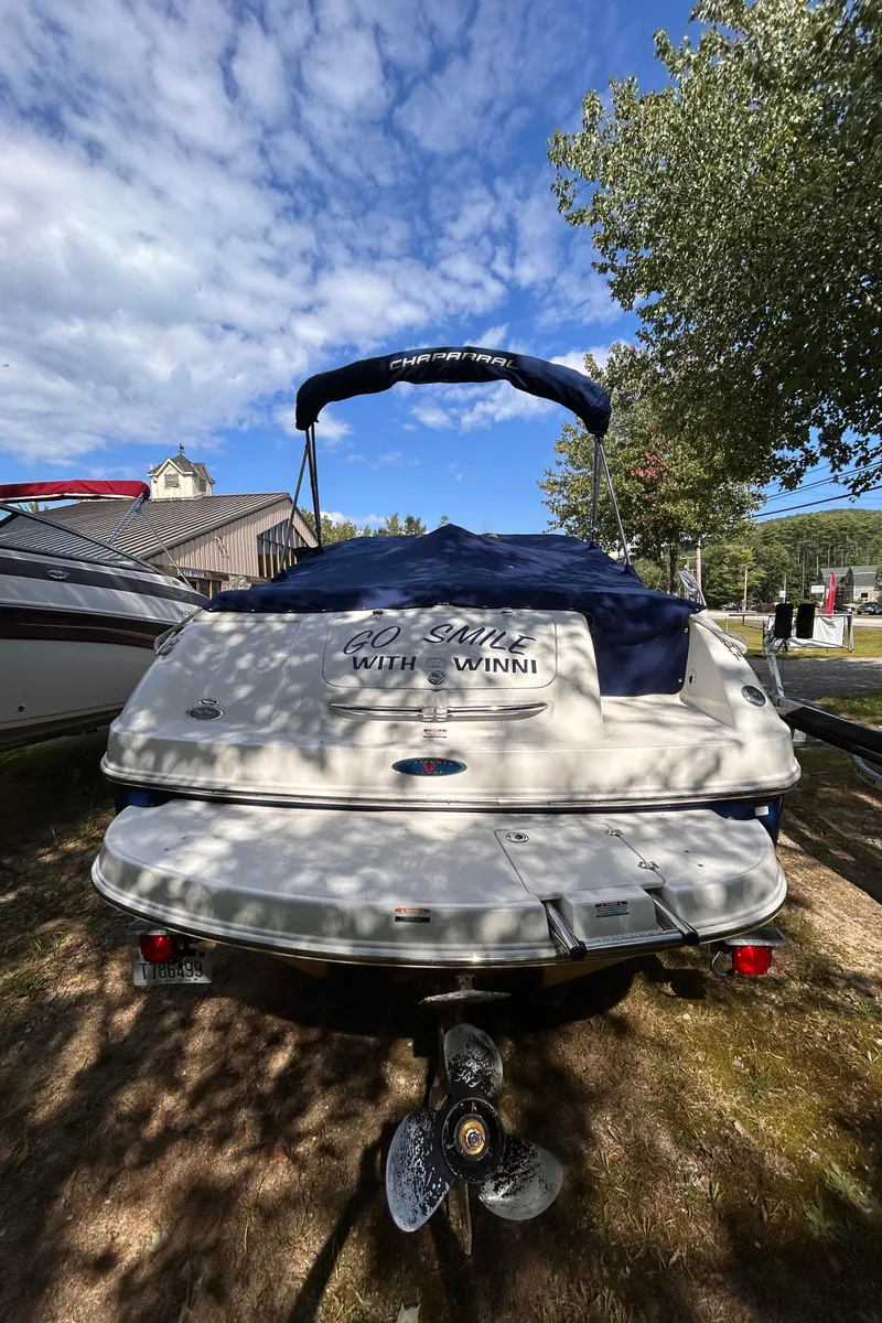 Slide: The Image of 2005 Chaparral 215 SSi boat, covered, parked outdoors under a blue sky. - 4