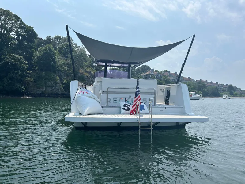 Slide: The Image of 2012 Fjord 40 Open yacht on water, rear view with American flag and canopy. - 2