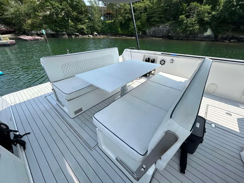 Slide: The Image of 2012 Fjord 40 Open yacht with sleek seating and table on deck, surrounded by serene water. - 3