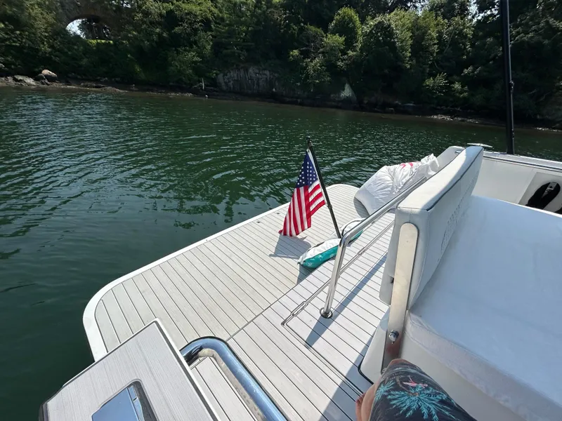 Slide: The Image of 2012 Fjord 40 Open yacht deck with American flag, surrounded by calm water and lush greenery. - 5