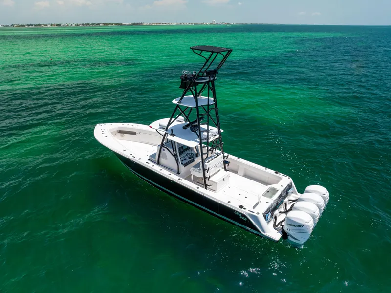 Slide: The Image of 2008 SeaVee 390 B boat on clear turquoise water, featuring triple outboard engines. - 17