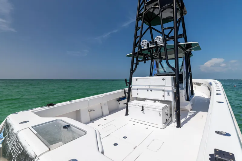 Slide: The Image of 2008 SeaVee 390 B boat on clear ocean water, featuring a spacious deck and tower. - 21