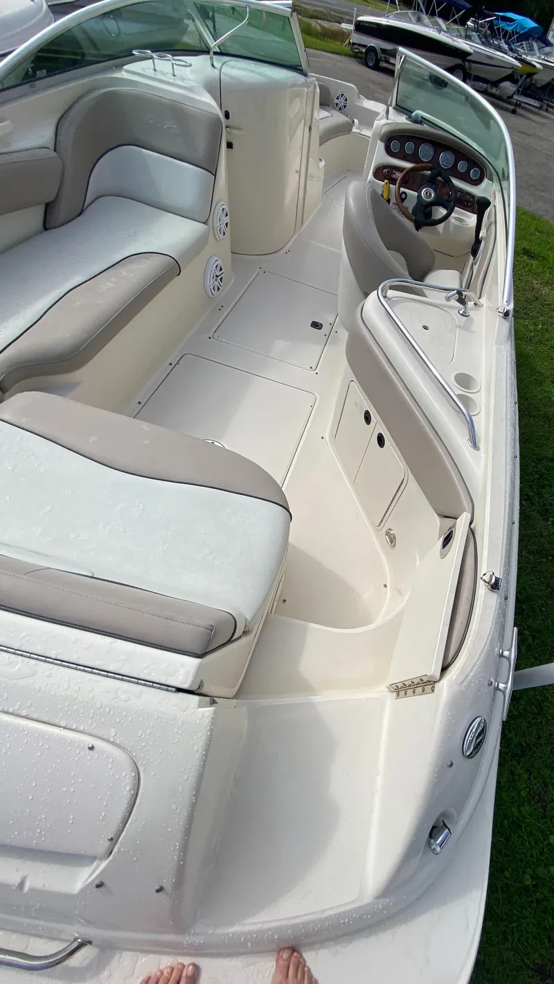 Slide: The Image of 2004 Sea Ray 240 Sundeck interior with seating and helm, showcasing spacious design. - 10