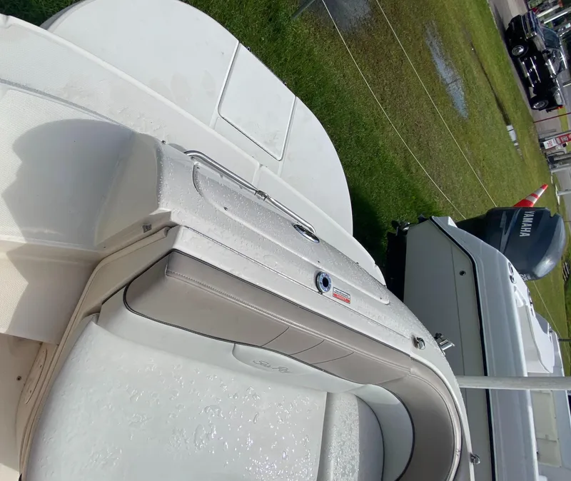 Slide: The Image of 2004 Sea Ray 240 Sundeck boat interior with white seating and deck. - 11